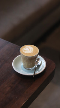 Latte art on te wood table in the coffee shop