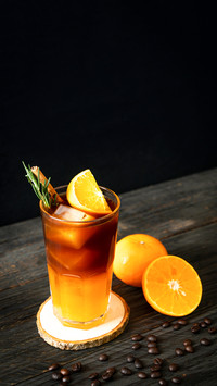 A glass of iced americano black coffee and layer of orange