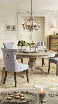 Grey upholstered chairs around silver tray on round