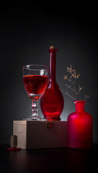 Elegant Still Life: Red Wine, Glass, and a Rustic Wooden Bas