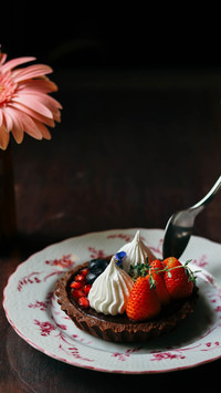 Tasty Chocolate tart with strawberry and berry on the table
