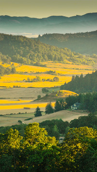 Farmland between colorful mountains