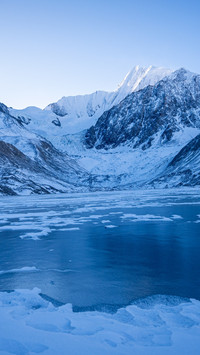 The frozen lake is still as a mirror's tale.
