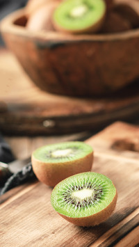 Organic fresh kiwi on a wooden cutting board and utensils