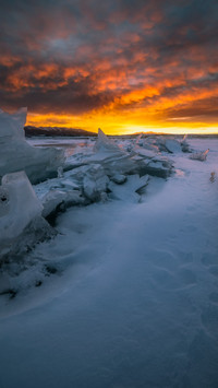 Dawn light faintly shines on the frozen lake.