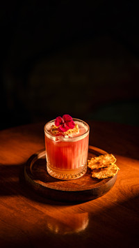 A beautifully crafted cocktail with a vibrant flower garnish