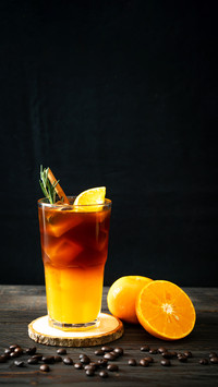 A glass of iced americano black coffee and layer of orange