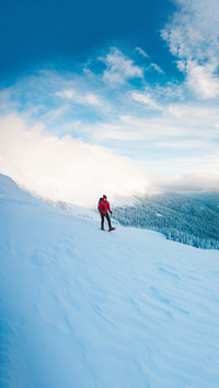 A man in snowshoes and trekking sticks in the mountains