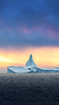 Iceberg ice formation in front of midnight sun in Antarctica