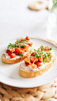Tomato bread with ricotta and micro grass on white plate