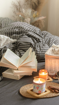 Candles and a Book Lie on the Bed in the Living Room