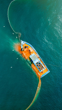 Fisherman catching fish using net at the ocean