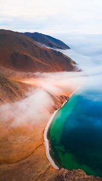 Fog over the shore of Baikal lake and mountains