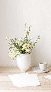Blueberry branches in ceramic vase pot on wooden table