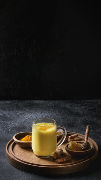 Cup of golden milk turmeric latte with curcuma powder