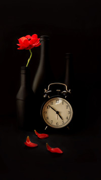 Clock on black background and black bottles and vases