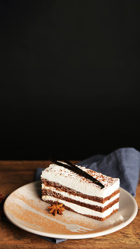 Tasty tiramisu cake on plate, on wooden table