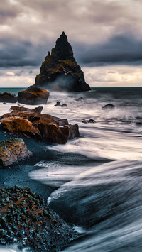 The contrast between rocks on the sea and the sky