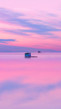 A waterside wooden hut with sky's reflection