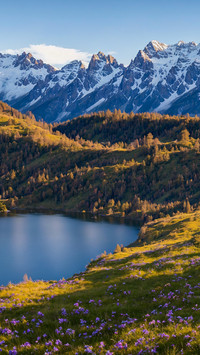 The snow capped mountain lake surface is as calm as a
