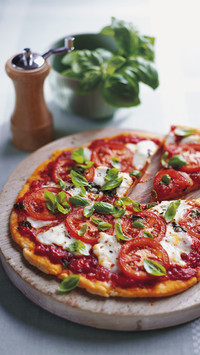 Pizza margherita topped with tomato sauce sliced tomatoes