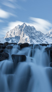 Waterfalls cascade down the snowcapped mountains of jade