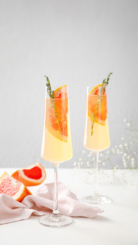 Glasses of Tasty Grapefruit Cocktail on Light Background