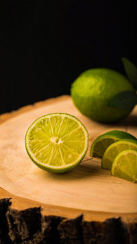 Fresh ripe limes on wooden background