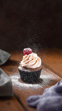 Powdered sugar falls on the muffin