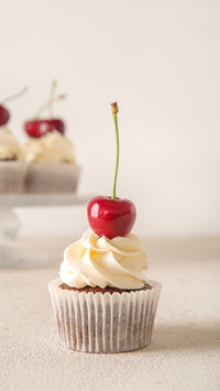 Tasty cherry cupcake on light background