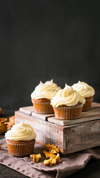 Carrot cupcakes or muffins with nuts on dark background