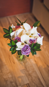 A beautiful bouquet of flowers stands in a vase on the floor