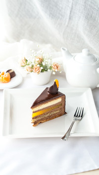 Slice of cake with Chocolate Glaze and orange on plate