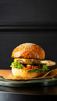 Close up of burger on black table and potato fries