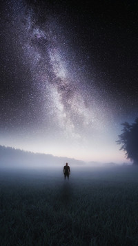 Man Standing Alone on The Grass Under The Stars