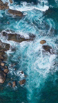 The waves crash against the rocks