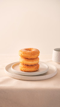 Stack of homemade baked donuts sitting on white plate