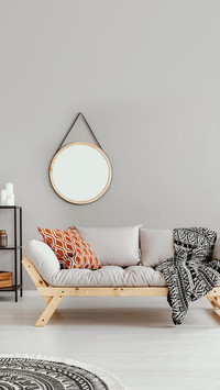 Mockup of round mirror above grey settee and blanket