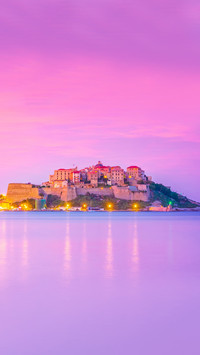 Historic buildings and yacht boats in Calvi port at night