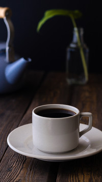 White cup with blue pot on a rustic wooden table