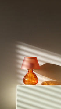Lamp on fireplace with wall shadows from window