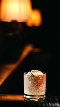 Vertical view of lime cocktail on a black leather sofa