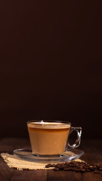 Coffee served on wooden table with brown background