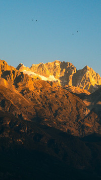 Sunrise on Jade Dragon Snow Mountain shines on Jinshan Peak