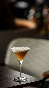 An elegant cocktail with coconut flakes on the table
