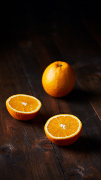Navel Oranges on a dark brown textured wooden surface