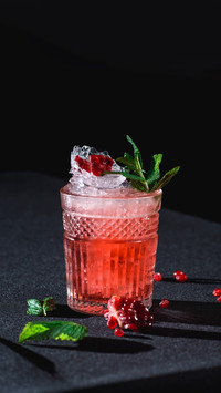 Cold cocktail with ice and garnet seeds