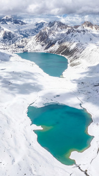 Aerial footage of Haizi Mountain Sister Lakes in winter snow