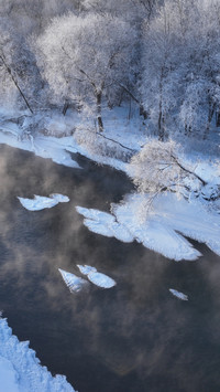 Frosty morning, cold fog locks the icy river