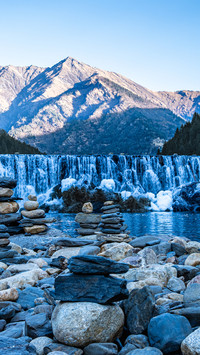 The waterfall at the foot of the snowcapped mountain